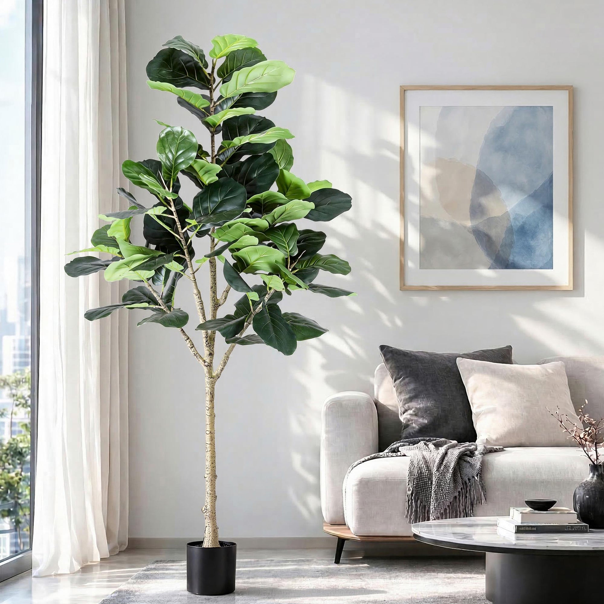Fiddle leaf fig plant in a living room with a sofa and artwork on the wall.