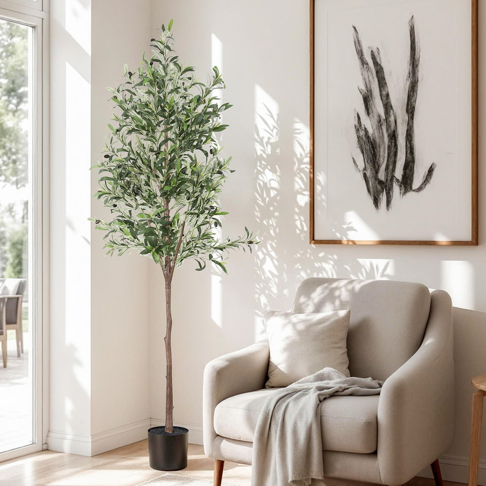 Living room with a potted plant, beige armchair, and abstract art on the wall.