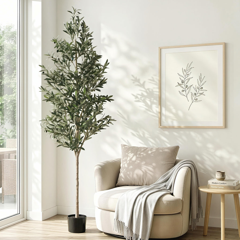 Living room with a beige armchair, potted plant, and framed artwork on a white wall.