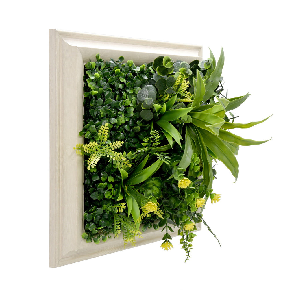 Artificial green wall with plants in a white frame on a white background